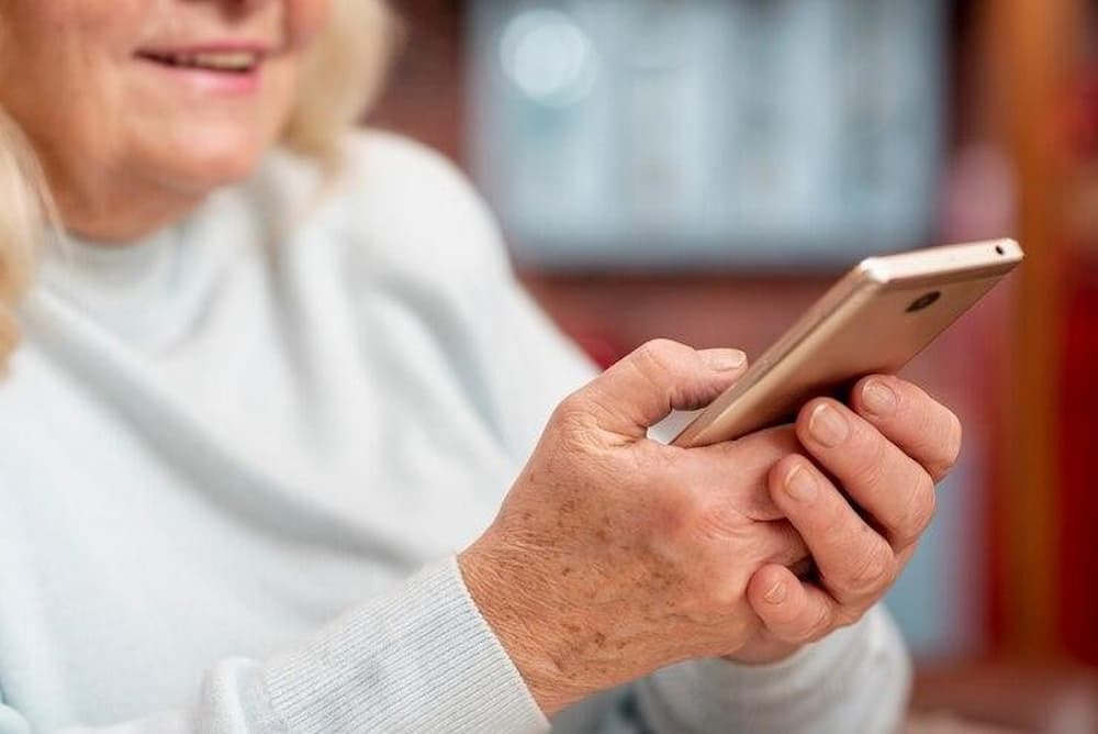 Mujer usando uno de los móviles para adultos mayores